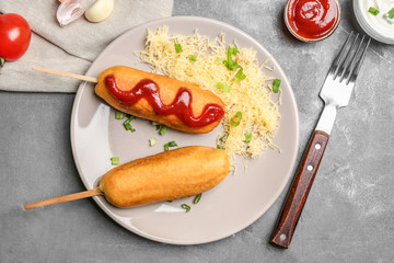 Wall Mural - Tasty corn dogs with ketchup on plate