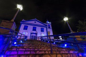 Ilhabela cathedral church Nossa Senhora D'ajuda at night with moon and cloudy sky - Sao Paulo, Brazil