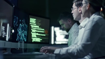 professional team of cyber security specialists writing program code and working with holographic ma