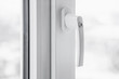 White secure UPVC window with lockable handle. Closeup, selective focus