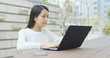 © leungchopan - Woman working on laptop computer at outdoor