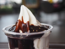 Close Up Vanilla Sundae Ice Cream With Chocolate Sauce And In Cup Blur Back Ground.