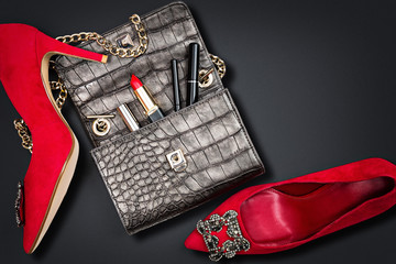 Luxury woman accessories. Handbag and high heels, isolated on dark background. Top view.