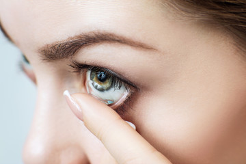 Wall Mural - Close-up shot of young woman wearing contact lens.