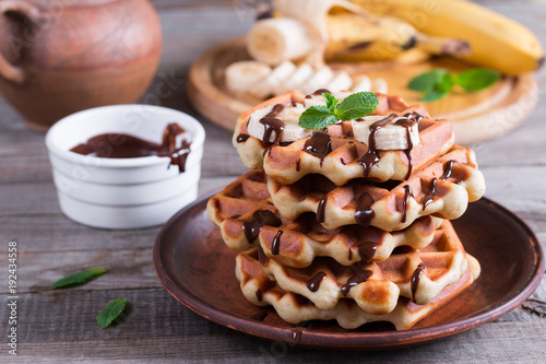 Fotografía Homemade Belgian waffles with chocolate sauce and banana slice on a plate