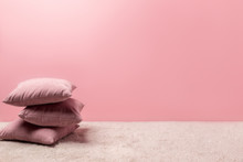 Stack Of Pillows On Carpet In Front Of Pink Wall