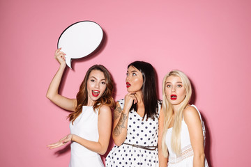 Wall Mural - Portrait of three cheery young women wearing dresses