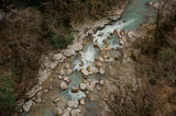 Fototapeta Sawanna - Top view of a powerful blue river stream flowing in forest
