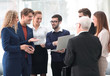 © ASDF - successful business team discussing documents and ideas standing near desktop