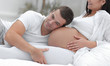 © ASDF - Husband listening to his wife's belly at home