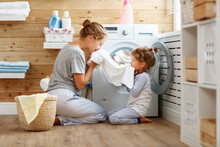 Happy Family Mother Housewife And Child   In Laundry With Washing Machine