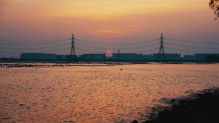 Wall Mural - Beauty of sunset sky over oil refinery industry background water front.