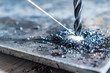 close up of drilling a hole with metal shavings an beam of lubricate liquid
