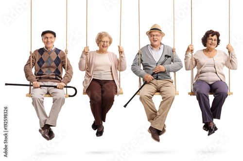 Fotografie, Obraz Cheerful seniors sitting on wooden swings and looking at the camera