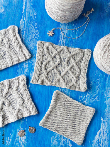 Knitting Patterns And Clews Of Wool On A Blue Wooden Table Knitting Patterns And Clews Of Wool On A Blue Wooden Table
