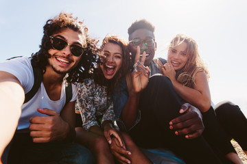 Wall Mural - Excited friends taking selfie outdoors