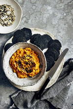 Carrot, Cumin And Cashew Nut Dip With Charcoal Crackers And Sesame Seeds.