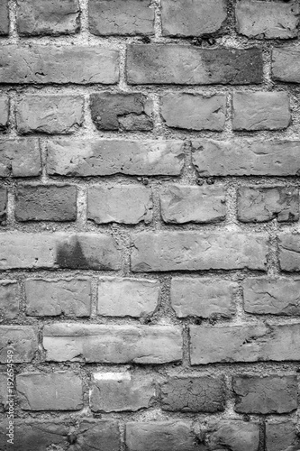 Fotografia, Obraz Old deteriorated brick wall texture background in black and white with vignetting