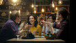 © Gorodenkoff - Diverse Group of Friends Celebrate with a Toast and Raise Wine Glasses in Celebration. Beautiful Young People Have Fun in the Stylish Bar/ Restaurant.