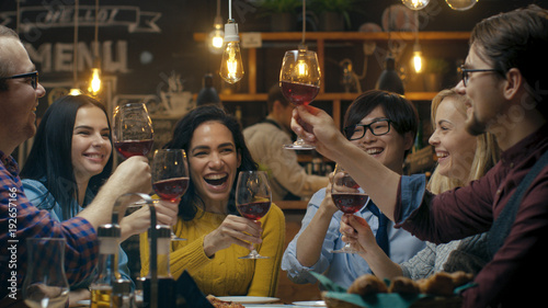 Diverse Group of Friends Celebrate with a Toast and Clink Raised Wine Glasses in Celebration Tableau sur Toile