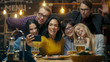 © Gorodenkoff - In the Bar/ Restaurant Hispanic Woman Takes Selfie of Herself and Her Best Friends. Group Beautiful Young People in Stylish Establishment.