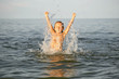 Spray with water. Girl having fun bathing in the sea.
