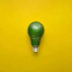 Fresh idea / Creative concept photo of avocado as electric bulb on yellow background.