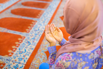 Young muslim woman praying in mosque