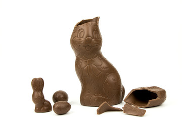 
Chocolate Easter bunny with broken ears and chocolate Easter eggs isolated on white