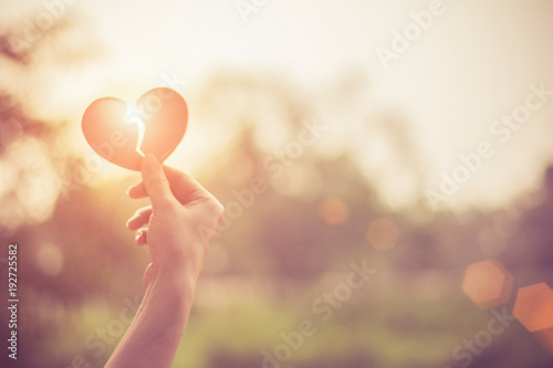 Cuadros en Lienzo Silhouette broken heart,close up woman hand holding broken heart in the park