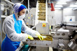 © pressmaster - Staff of seafood production factory carrying out his work by industrial seaweed salad mixing machine