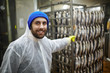 © pressmaster - Happy young staff in coveralls working in fish smoke department