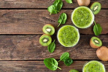 Poster - Kiwi smoothie drink of spinach leaves and fresh fruits on wooden rustic table, healthy detox diet