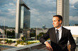 © Pavel - Portrait of businessman standing in front of modern building