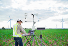 Engineer Using Tablet Computer Collect Data With Meteorological Instrument To Measure The Wind Speed, Temperature And Humidity And Solar Cell System On Corn Field Background, Smart Agriculture Concept