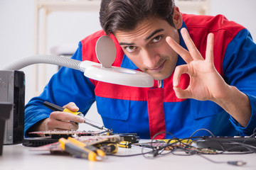 Professional repairman repairing computer in workshop