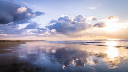 walking along the beach during sunset in ijmuiden the netherlands,