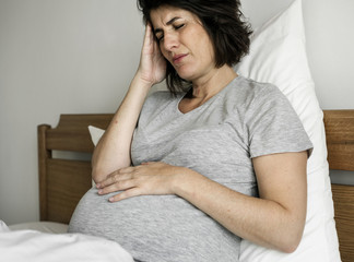 Wall Mural - Pregnant woman with a headache