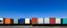 Semi Trailers Lined Up On The Ground With Blue Sky Background