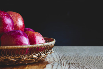 Delicious juicy apples. in a wooden basket. On a wooden table!
On a black background.