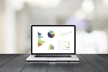 Poster - Laptop on wooden table showing charts and graph