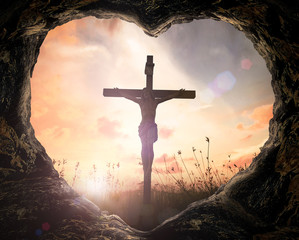 good friday concept: heart shape of cave with jesus christ on cross over meadow sunset background.