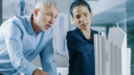 Aufkleber - Male Senior Engineer and Female Architectural Designer Work on a Building Model Design for the Urban Planning Project.