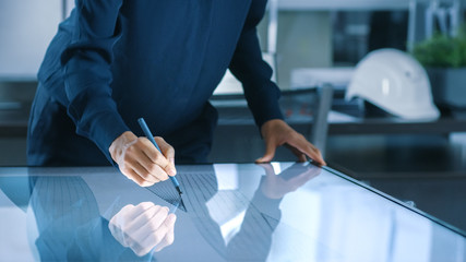 Aufkleber - Talented Young Female Architectural Designer Draws Building Concept on a Graphics Tablet Display Vertical Touchscreen Table. Clean Minimalistic Office, Concrete Walls Covered by Blueprints.