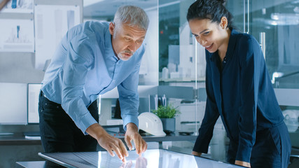 Aufkleber - Senior Male and Young Female Architectural Designers Draw Building Concept on a Graphics Tablet Display Vertical Touchscreen Table. They Use Gestures for Zooming Project Model.