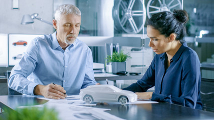 Aufkleber - Experienced Automotive Designer and Female Engineer Works with Blueprints and Sketches of a New Car Prototype Model.