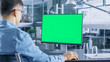 © Gorodenkoff - Automotive Engineer Working on a Personal Computer With Isolated Mock-up Green Screen on it. He Works in the Bright and Modern Office with Car Sketches on the Walls.