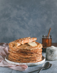 Stack of traditional russian pancakes blini on gray background with copy space. Homemade russian thin pancakes blini. Russian food, russian kitchen