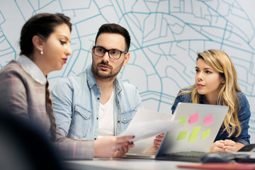 Wall Mural - A business team of three sitting in office and planning work