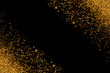 Defocused gold glitter with glowing sparks lights on a black background. Holiday greeting card